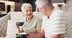 Coffee, funny and retirement with old couple on sofa in living room of home together for break. Conversation, bonding and laughing with senior people drinking beverage in apartment for wellness