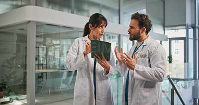 Buy stock photo Tablet, report and doctors with talk in hospital lobby for advice with surgery, medicine or treatment plan. Teamwork, woman and man with information, document and support for healthcare professional