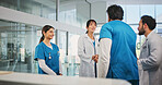 Doctors, handshake and team in lobby with talk, congratulations and success with promotion at hospital. People, group and shaking hands for achievement, praise or thanks with medical career at clinic