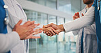 Handshake, applause and doctors in hospital for agreement, support or medical deal together. Shaking hands, greeting and healthcare employees with welcome, collaboration or teamwork in clinic.