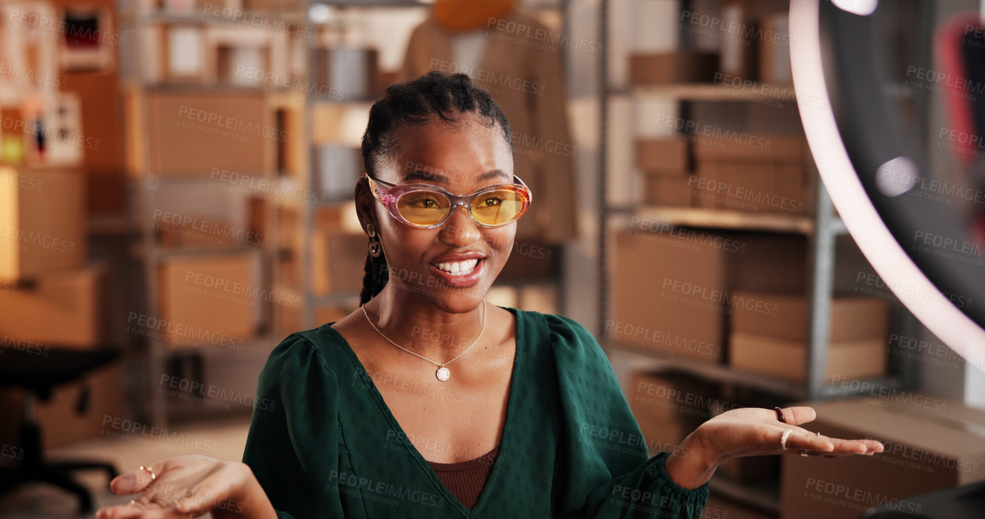 Buy stock photo Sunglasses, live stream and advertising with black woman in warehouse for startup promotion and ecommerce. Content creation, online shopping broadcast and influencer with person and accessory