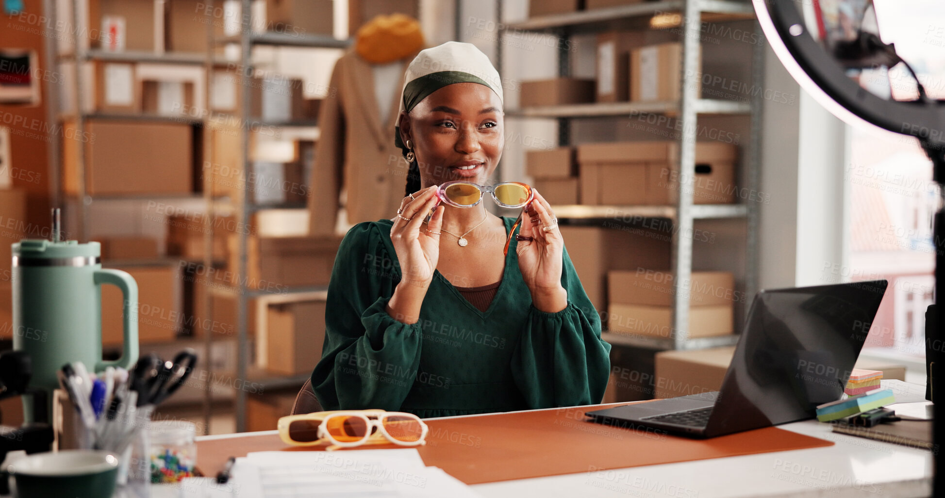 Buy stock photo Sunglasses, ecommerce and promotion with black woman in warehouse for startup, influencer and ring light. Content creation, online shopping broadcast and live streaming with person and accessory
