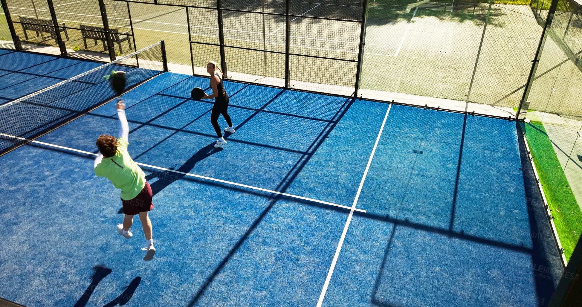 Buy stock photo People, padel game and team with racket, above and practice for competition at tennis court. Athlete, partner and training with double challenge, workout or jump with fitness at sports club in summer