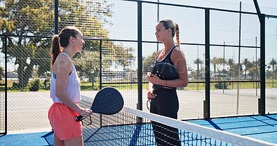 Buy stock photo Conversation, fitness and padel with women on court together for practice or training session. Exercise, sports or tennis with coach and player talking outdoor for development or skill with technique