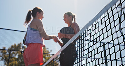Buy stock photo Women, handshake and smile for match at tennis court, low angle and respect with padel game. People, happy and shaking hands with racket, thanks or motivation in summer for fitness at sports club