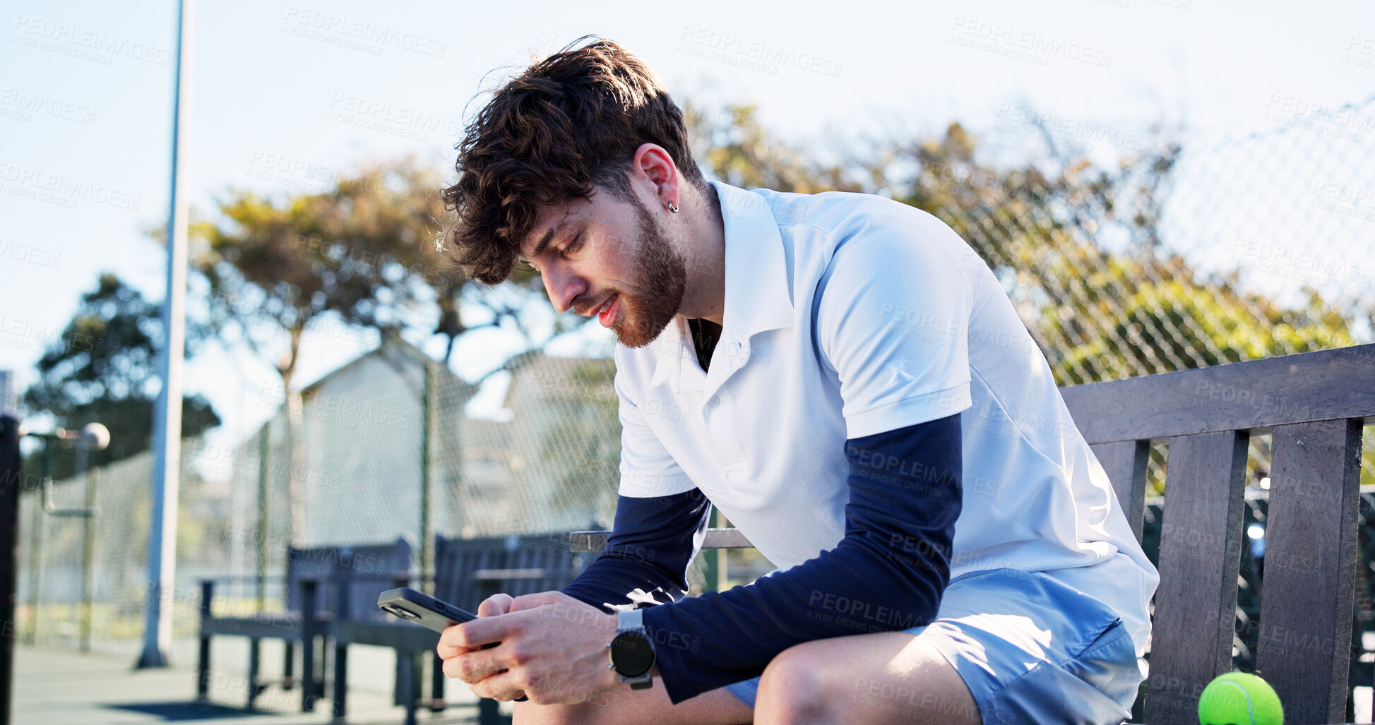 Buy stock photo Athlete, man and relax with phone on tennis court for fitness, training app and match progress. Happy, male person and mobile on bench for sports break, video demonstration and online results of game
