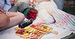 Couple, partner and charcuterie board with wine for picnic, date and bonding together with healthy snack. People, relax and meat or cheese platter with alcohol for drink, commitment and connection