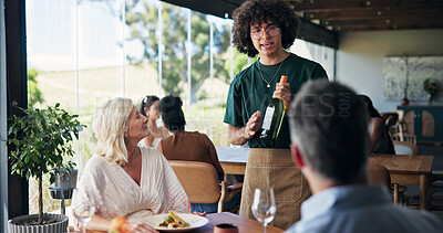 Buy stock photo Wine bottle, hospitality and couple in restaurant, waiter and conversation with customer service. People, employee and men with mature woman, alcohol and choice with fine dining, host and tasting