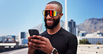 Black man, runner and phone with smile in city, sunglasses and scroll with fitness, break and post on web. Person, happy and smartphone with mobile app, training or rest with chat on bridge in town