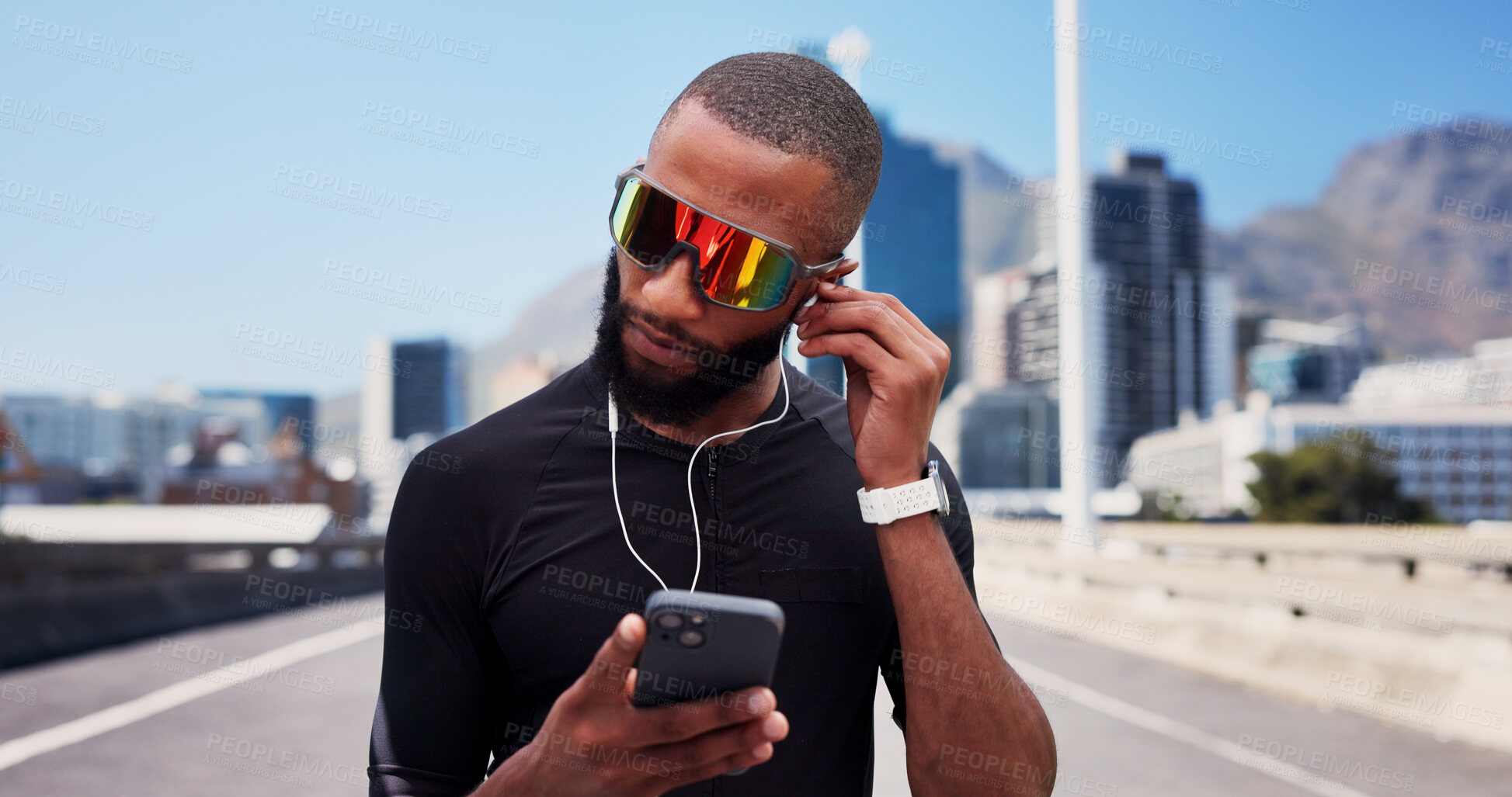 Buy stock photo Black man, runner and phone with earphones on bridge, sunglasses and exercise with streaming in city. Person, sound and smartphone with mobile app, click or listen to music for fitness in urban town