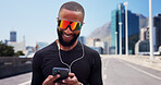 Black man, runner and phone with earphones in city, sunglasses and smile with fitness, streaming or sound. Person, happy and smartphone with mobile app, audio or listen to music on bridge in town