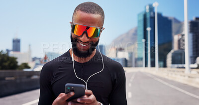 Buy stock photo Black man, runner and phone with earphones in city, sunglasses and smile with fitness, streaming or sound. Person, happy and smartphone with mobile app, audio or listen to music on bridge in town