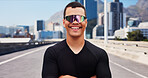 Outdoor, athlete and man with sunglasses, happy or confident for fitness with sportswear and workout. City, runner and person with shades for exercise routine, healthy and pride on street in USA