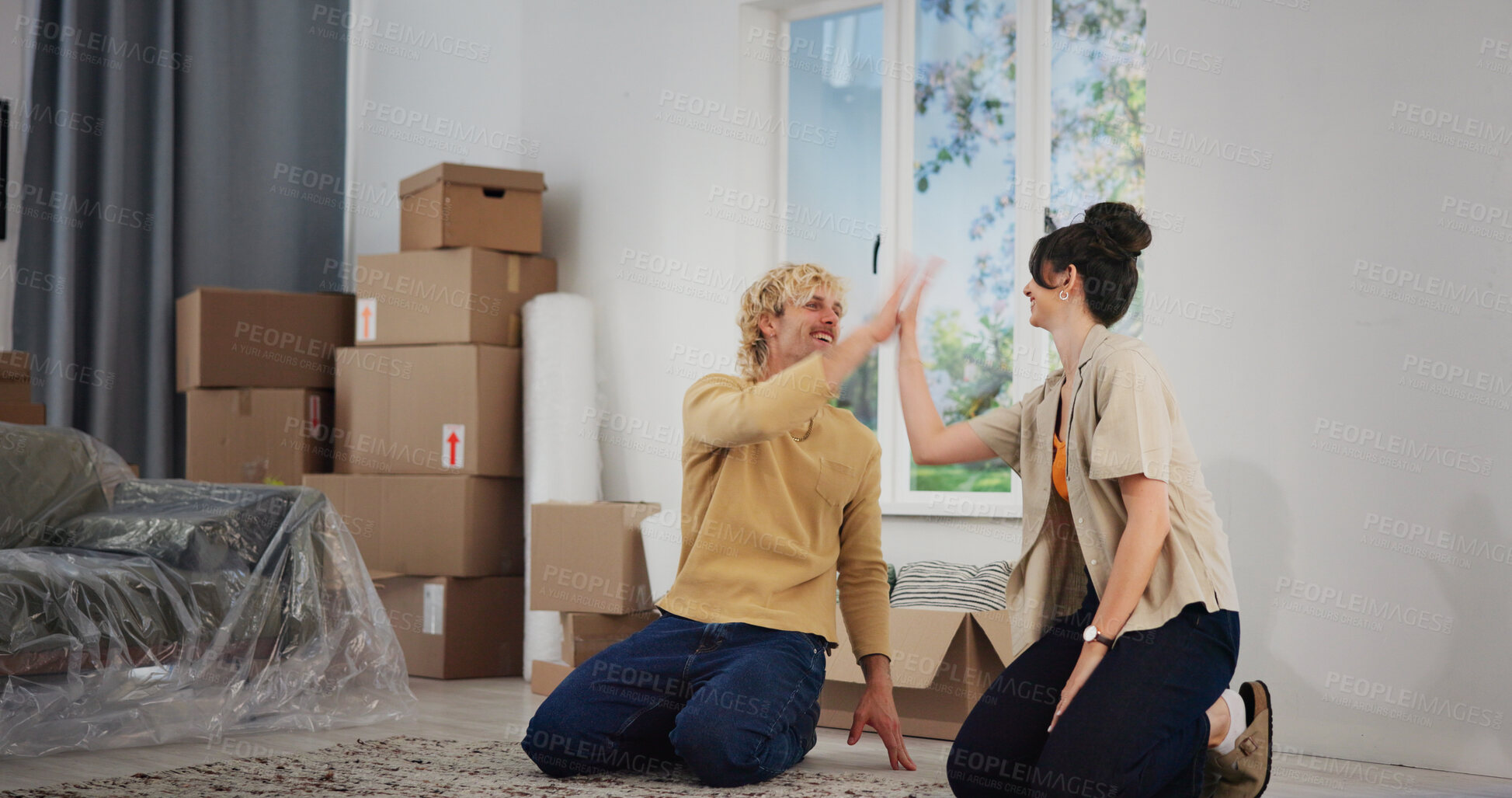 Buy stock photo Couple, high five and moving in with boxes in new home for bonding, connection and celebration in property. People, teamwork and relocation in living room for love, real estate and investment
