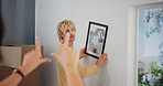 Hanging picture, moving day and position with couple in new home together for interior design. Boxes, finger frame and love with people in apartment for growth, property or real estate investment
