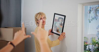 Buy stock photo Hanging picture, moving day and position with couple in new home together for interior design. Boxes, finger frame and love with people in apartment for growth, property or real estate investment