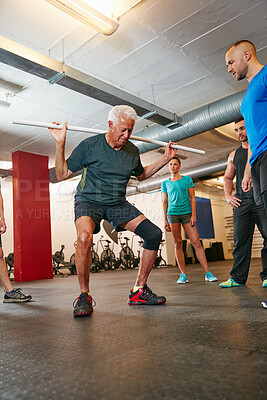 Buy stock photo Personal trainer, senior man and squat in gym with pipe for mobility exercise, physical activity or wellness. Coach, old person or pvc equipment with advice for workout, fitness support or low angle.