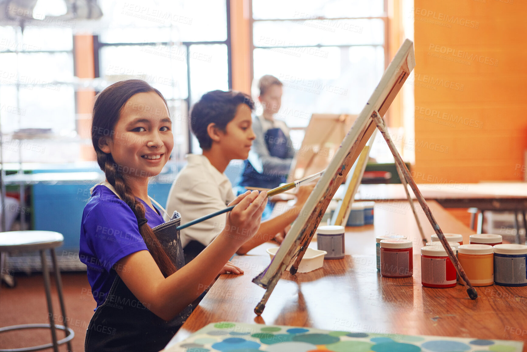 Buy stock photo Portrait, painting and girl with smile for art class, creativity support or fine motor skill development. Education, artistic learning and happy students with canvas for lesson, paint brush and child