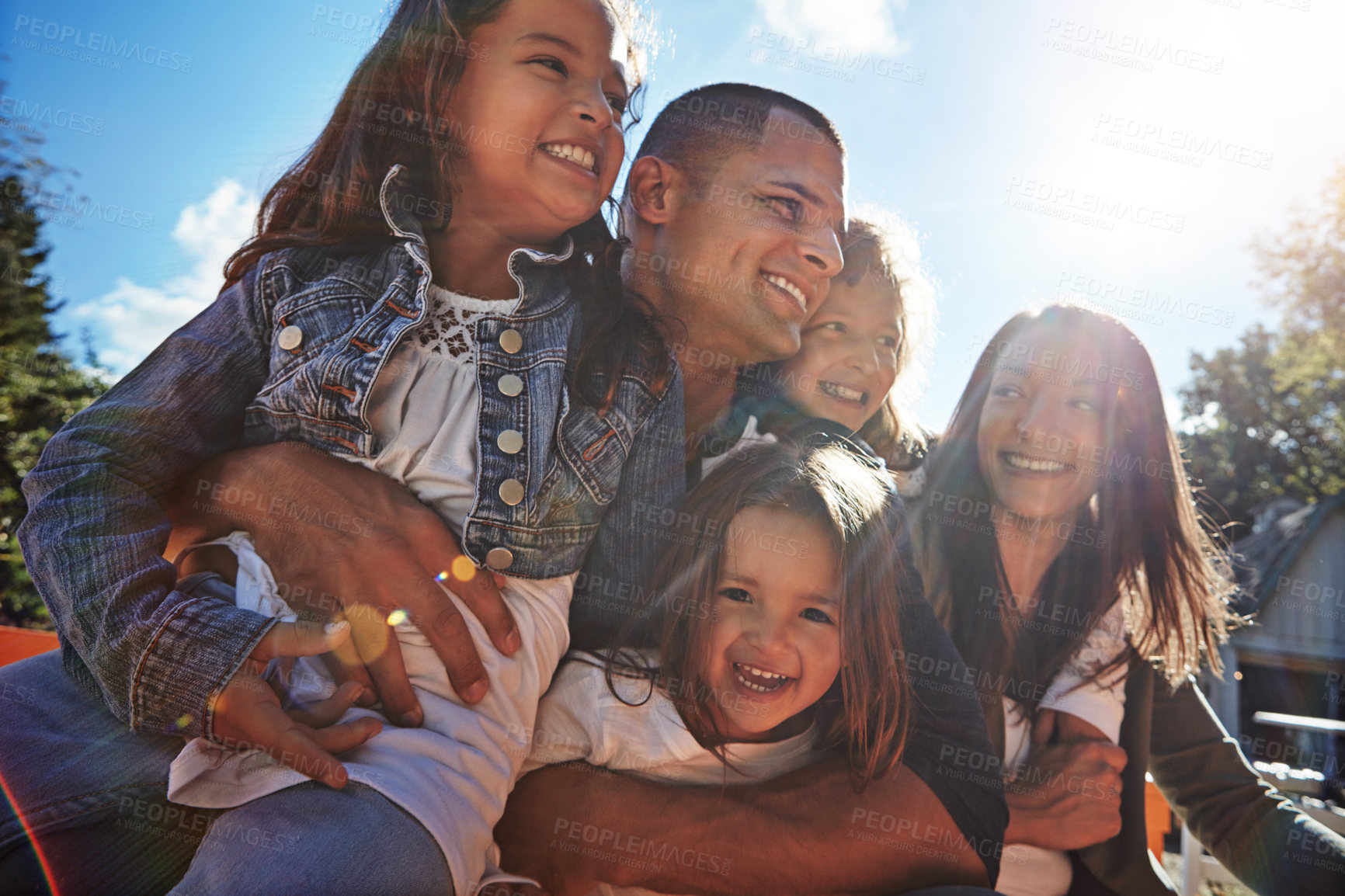 Buy stock photo Parents, children and happy with hug outdoor for family fun, weekend break and healthy relationship. Lens flare, mother and father with kids on holiday with bonding, support and embrace at farmhouse