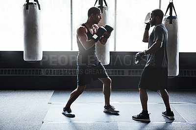 Buy stock photo Fitness, instructor and man with boxing gloves in gym, strength drills and cardio training in practice. Personal trainer, skill development or athlete with gear for punching routine, workout or flare