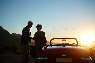 Buy stock photo Sunset, senior couple and car on mountain for road trip break, retirement getaway or bonding. Dusk, old people and relax at convertible for sightseeing, journey and travel adventure with mockup space