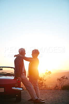 Buy stock photo Sunset, road trip and senior couple with love in nature for travel break, romantic getaway and support. Sunlight, mockup space and old people with hug at convertible car for journey pause and flare