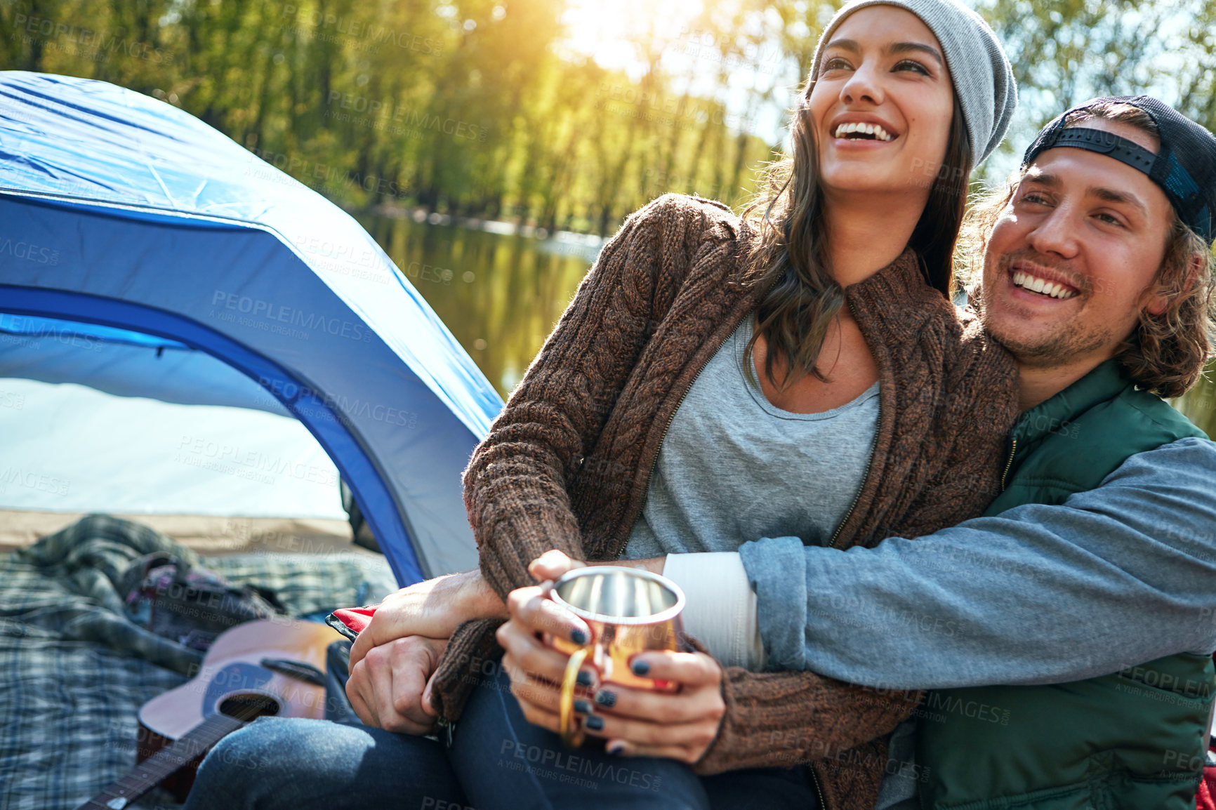 Buy stock photo Happy couple, hug outdoor and tent with cup, camping adventure or bonding together for connection. Dating, people smile or embrace in nature with campsite, travel mug or romantic getaway for weekend.