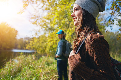 Buy stock photo Happy woman, couple and hike in nature with backpack, lake scenery and bonding together on weekend. Female person smile, bag and trekking outdoor with partner, reflection and explore for adventure.