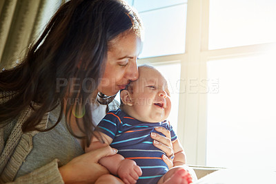 Buy stock photo Love, mother and baby with kiss in home for child development, connection or security. Happy family, woman or infant with affection at window for bonding together, relationship or trust with sunshine