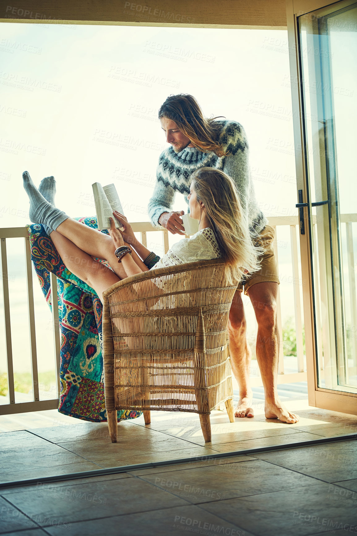 Buy stock photo Boho, reading and couple on balcony of lodge together for holiday, vacation or weekend getaway. Bonding, relax or travel with man and woman drinking coffee outdoor at guest house for storytelling