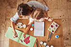 Top view, mother and child art painting in house studio, family home or creative space with brush, oil paint or books. Mom, parent or child hands bonding in abstract design or relax activity on table