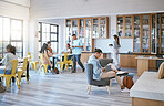 Education, students and learning in library at university in relax, funky and creative study room. Diversity, college and learners in social space, reading, homework and research with book and pupils