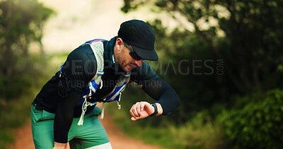 Buy stock photo Fitness, watch and man in nature with running, workout or training for wellness outdoor. Tired, breathing and male athlete checking health activity for cardio exercise in forest with break in morning