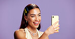 Beauty, selfie and smile with influencer woman in studio for product review on social media. App, haircare and happy with excited content creator isolated on purple background for post or update