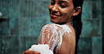 Woman, shoulder or soap in shower with water for cleaning, body care sponge or grooming in home. Happy female person, liquid or hygiene foam wash in bathroom with loofah, skincare product or wellness