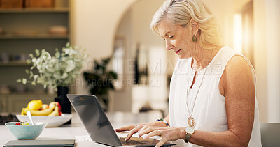 Buy stock photo Mature woman, laptop and remote work from home, typing and editing report for deadline in kitchen. Person, freelance writer and computer for project management, flare and story on web at apartment