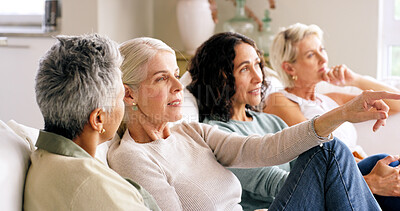 Buy stock photo Mature women, watching tv and point on sofa for movie choice, show or series in home. People, group or friends with smile, streaming or bonding for living room entertainment or reunion in house