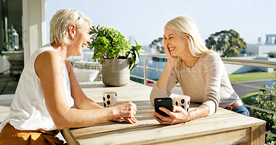 Buy stock photo Coffee, laughing and phone with mature friends on home balcony together for bonding or wellness. App, funny and relax with female people outdoor at apartment for break, meme or social media post