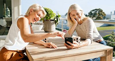 Buy stock photo Coffee, laughing and phone with mature women on home balcony together for bonding or streaming. App, funny and relax with female friends outdoor at apartment for break, meme or social media post