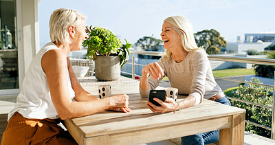 Buy stock photo Coffee, funny and phone with women friends on home balcony together for bonding or retirement. App, laughing and relax with mature people outdoor at apartment for break, meme or social media post