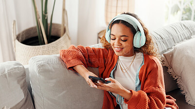 Buy stock photo Headphones, typing and woman with phone on couch, search music library and listening to podcast. Audio tech, relax and person with radio app for streaming in home, scroll social media and watch video