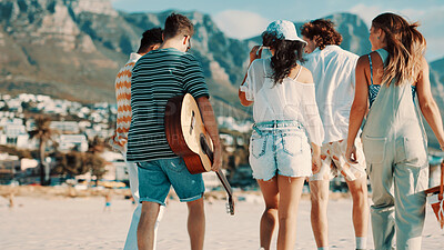 Buy stock photo Walking, friends and group on beach for holiday break, summer travel or outdoor picnic for tourism. Guitar, weekend trip and people together for vacation to relax, back or connection for relationship