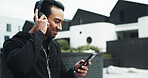Fitness, music and phone with man outdoor for cardio training, running or workout tracking. City, exercise and headphones with happy athlete or runner typing on mobile app for challenge or sports