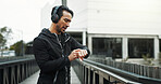 Headphones, athlete and check watch with running in city for workout progress, performance monitor or app. Runner, man and technology for training, fitness and exercise for podcast or music streaming