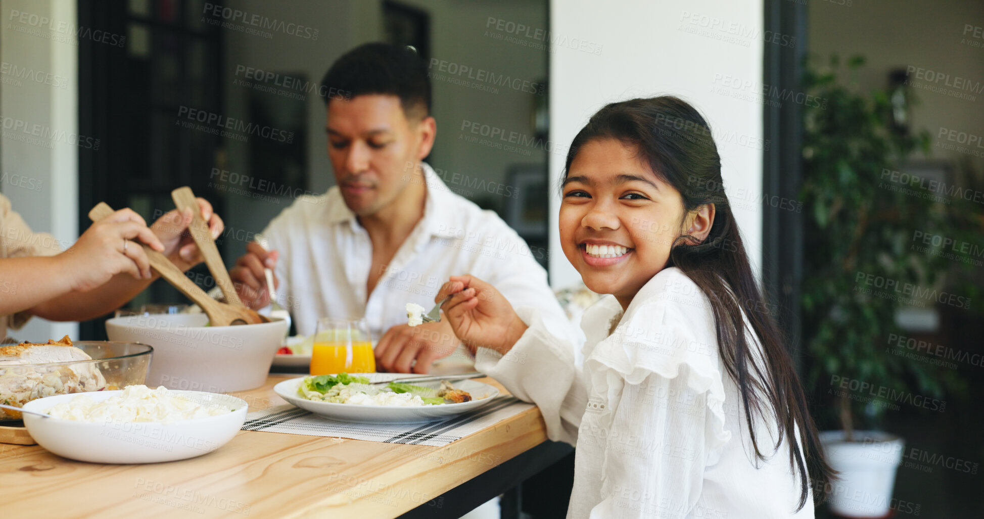 Buy stock photo Portrait, girl eating and family in home with food for healthy nutrition, lunch and bonding together. Happy, child and parents at dining table with plate for meal, cuisine and connection in house.