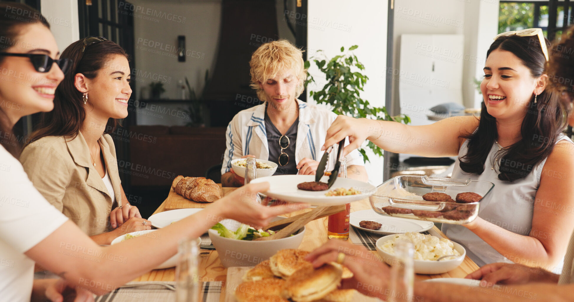 Buy stock photo Lunch, smile and serve with friends in house for food, social reunion and summer vacation. Gathering and party event with group of people eating in dining room of apartment for holiday and support