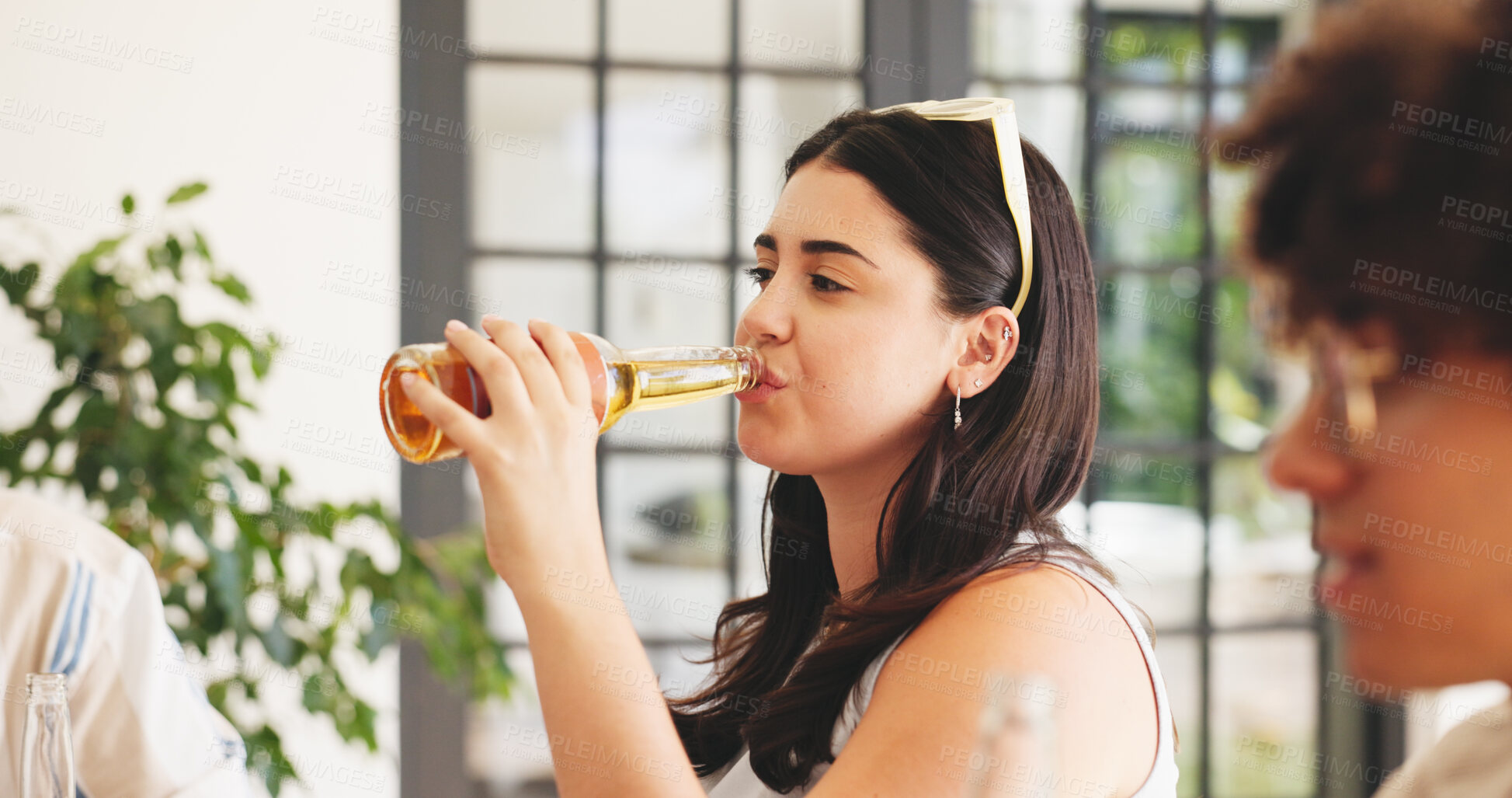 Buy stock photo Woman, drinking beer and relax in home with friends for summer holiday, social gathering or bonding. Female person, swallow alcohol and liquid with bottle in house for refreshment, chill and hangout.