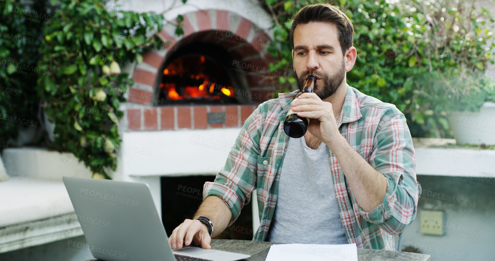 Buy stock photo Man, outdoor and beer with laptop for remote work, journalism and news report research. Technology, alcohol drink and typing in backyard with computer, contact or proposal for freelance writing