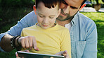 Tablet, father and child outdoor for game, bonding together and pointing at app for movie choice. Boy, dad and technology in nature for website, online film or watch series with parent on internet