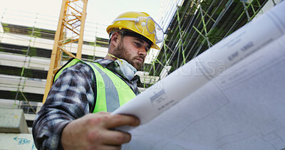 Buy stock photo Civil engineer, reading and man with blueprint, outdoor or property development on construction site. Building, floor plan and person with renovation project, low angle and architect with document